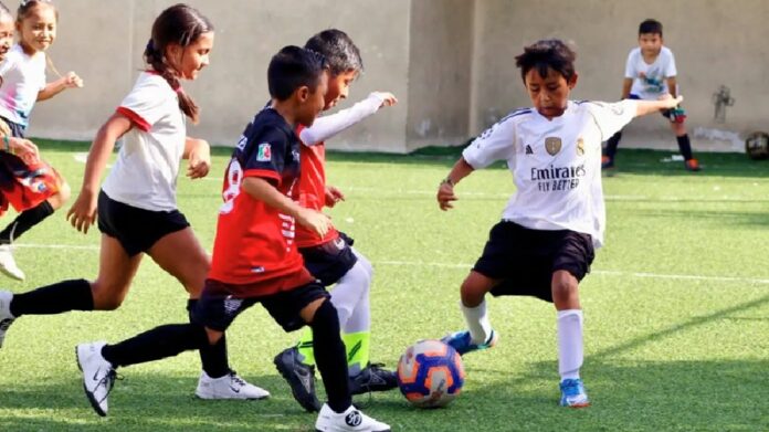 Niñas y niños disputan un partido de fútbol durante el Mundialito Social en una cancha de la unidad deportiva Luis Donaldo Colosio.