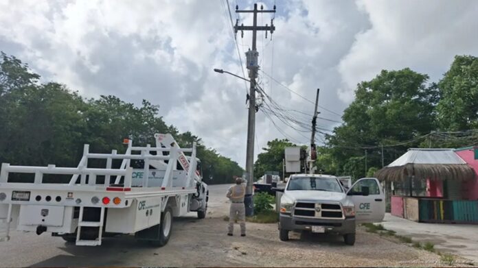 Personal y vehículos de la Comisión Federal de Electricidad realizan trabajos junto a un poste eléctrico en la colonia Esperanza.