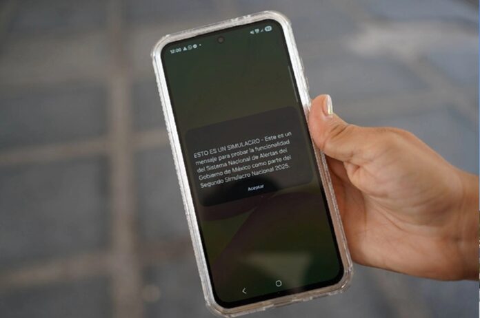Teléfono celular muestra un mensaje del Sistema Nacional de Alertas durante una demostración del nuevo esquema de notificaciones para emergencias meteorológicas.