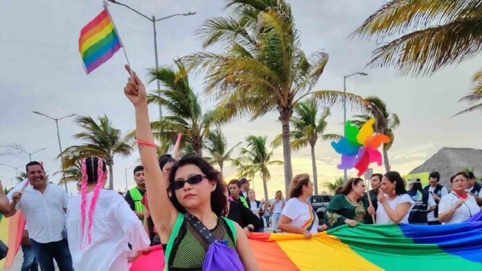 Participantes recorren las calles de Playa del Carmen durante la Marcha del Orgullo LGBT+ con banderas y mensajes de inclusión.