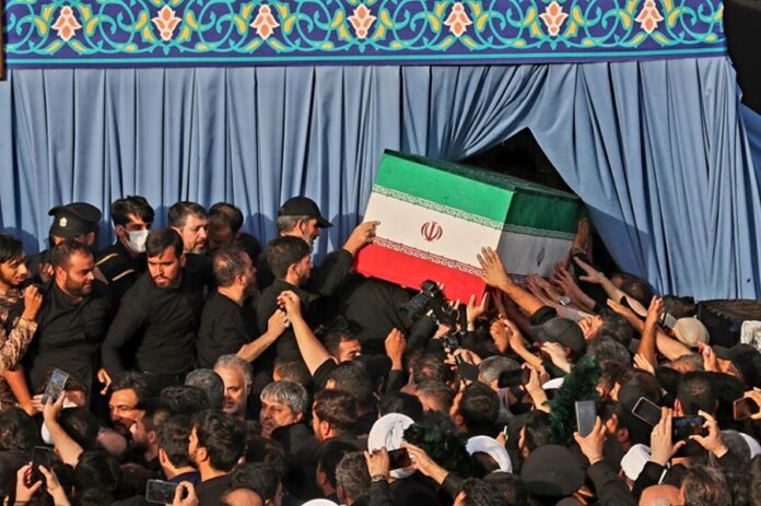 Personas trasladan un ataúd cubierto con la bandera de Irán durante una ceremonia fúnebre tras los bombardeos registrados en el país.