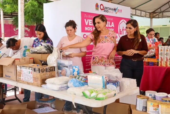 Mara Lezama y Verónica Lezama supervisan la clasificación de insumos y donativos sobre mesas durante la colecta humanitaria en Chetumal.