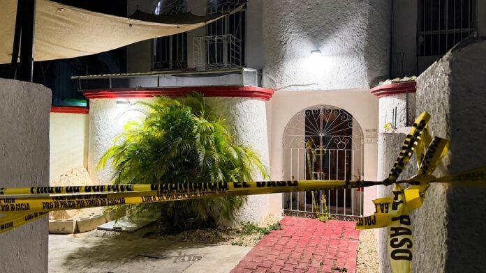 Personal de la Fiscalía realiza diligencias en un domicilio donde fue localizado el cuerpo de una mujer en Cancún.
