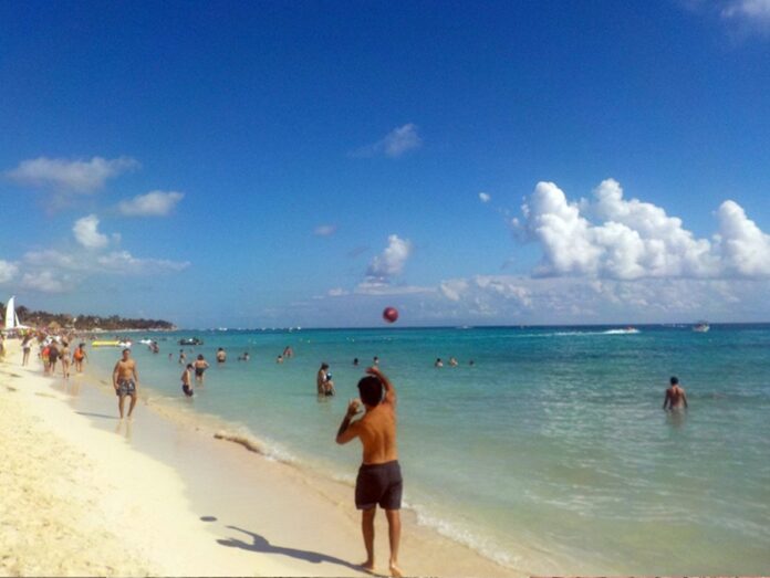 Bañistas disfrutan de una playa de Playa del Carmen con arena limpia, mar azul y escasa presencia de sargazo.