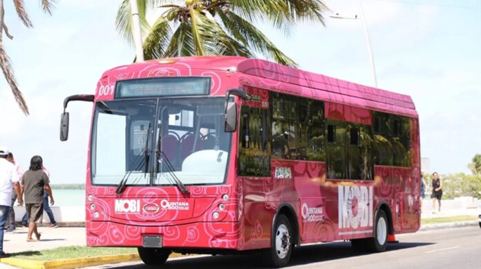 Autobús eléctrico del sistema MOBI circula sobre una avenida costera en Chetumal.