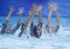 México domina los Juegos Centroamericanos y del Caribe Santo Domingo 2026 con 407 medallas Nadadoras de natación artística realizan una rutina dentro de una piscina mientras levantan los brazos entre salpicaduras de agua.
