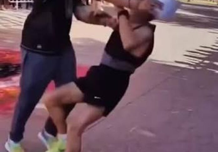 Un hombre empuja a un corredor adulto mayor a pocos metros de la meta durante una carrera atlética en Huamantla, Tlaxcala.