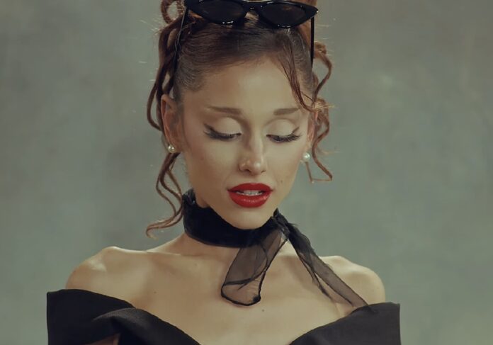 Ariana Grande interpreta una canción durante un concierto del Eternal Sunshine Tour frente a miles de asistentes.