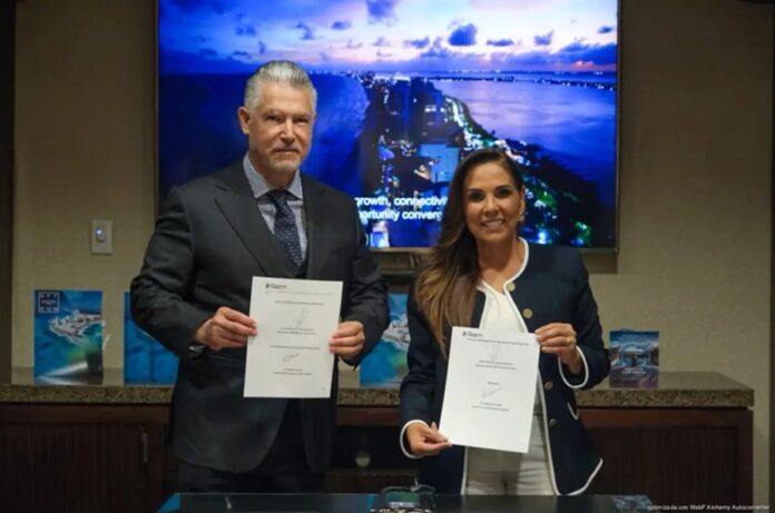 La gobernadora Mara Lezama y un representante de Mayan Healthcare Design sostienen documentos firmados durante la firma de un memorándum de entendimiento.