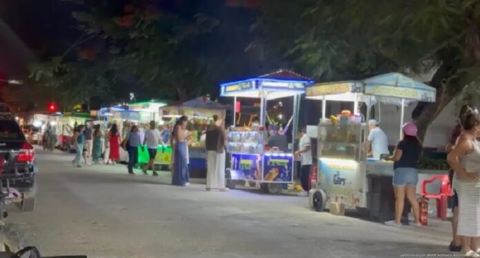 Puestos de venta instalados sobre una vialidad de Tulum.