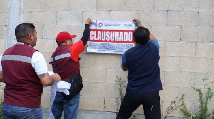 Sellos de clausura colocados en el acceso de un proyecto inmobiliario en Cancún.
