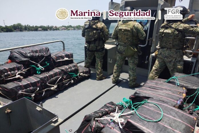Elementos de la Marina resguardan paquetes asegurados durante un operativo en aguas del Pacífico.